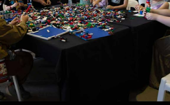 A table filled with LEGO elements available for people to build with